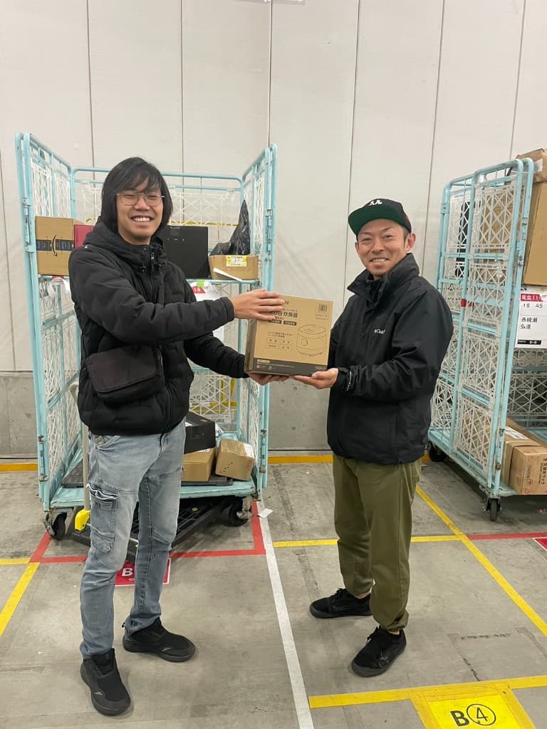 倉庫内で誕生日の贈り物を一緒に持つスタッフ