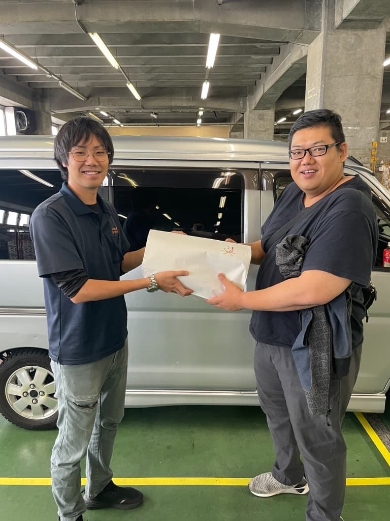 拠点で誕生日プレゼントの紙袋を手渡すスタッフ