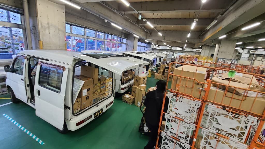 拠点で荷物を積み込み出発準備をする軽貨物車両